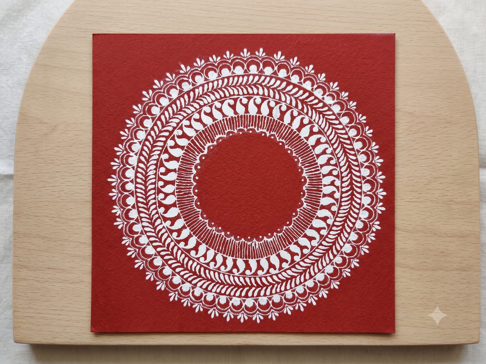 Hand-painted Kumaoni Aipan mandala on wooden board — heritage folk art for hospitality welcome amenities and corporate gifting